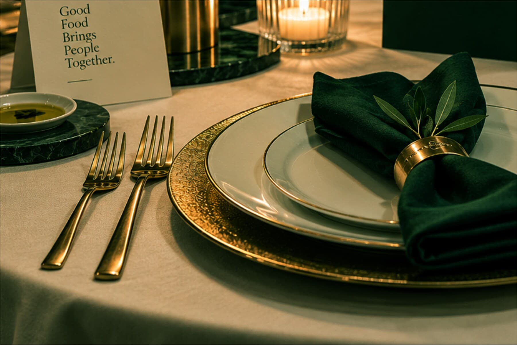 A candlelit table laid with gold-rimmed plates and a green linen napkin